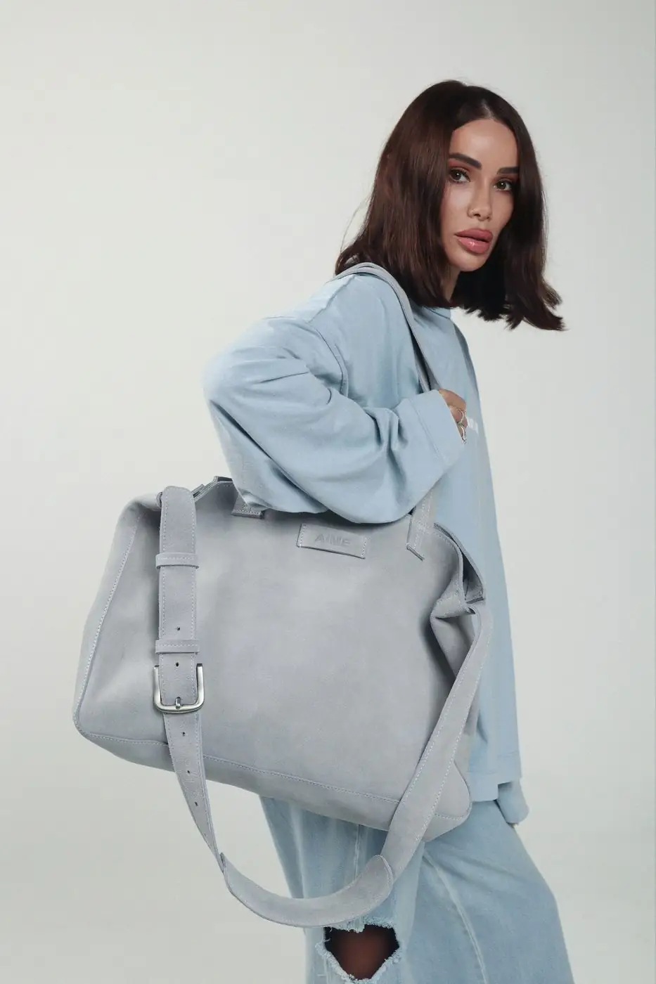 The Everything Tote Bag in mist suede, worn head to toe in blue